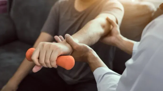 A physical therapist providing an in-home mobile physical therapy session