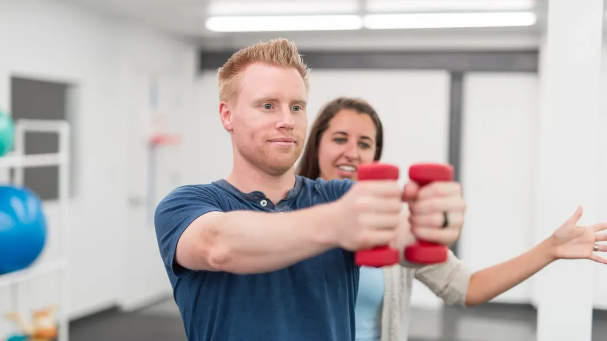 Physical therapist examining a patient's shoulder during a physical therapy session