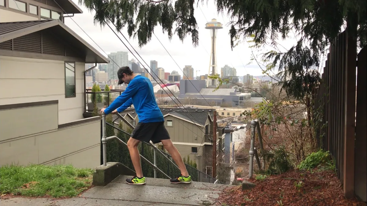 Dan performing a calf stretch on a stairway