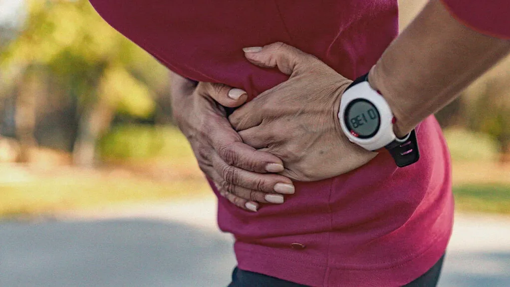 Person holding the left side of their body in pain