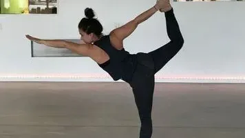 A person performing the standing bow yoga pose