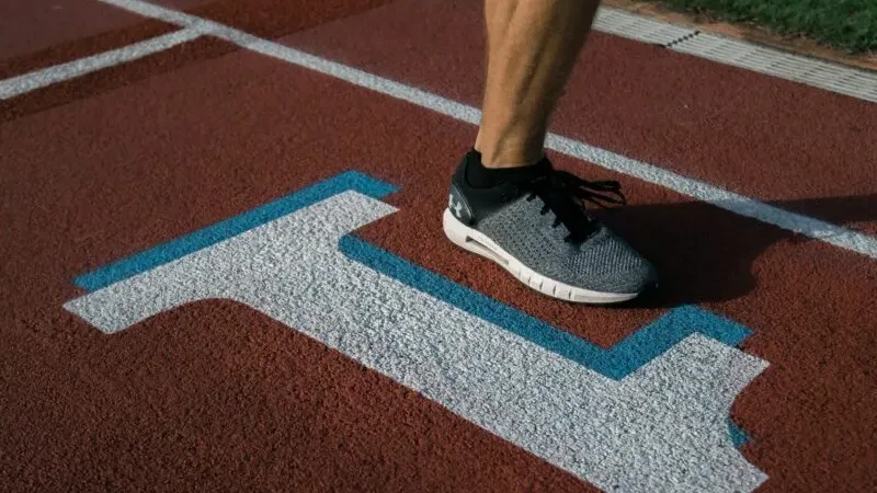 A runner training on an outdoor track as part of a return-to-race training plan