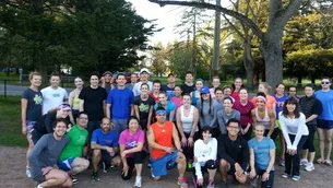 Group photo of runners gathered at Green Lake Park for a Monday night track workout