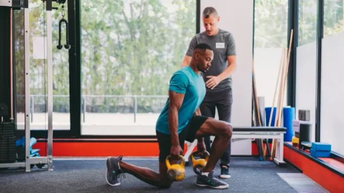 A sports rehabilitation trainer guiding an athlete through personal training