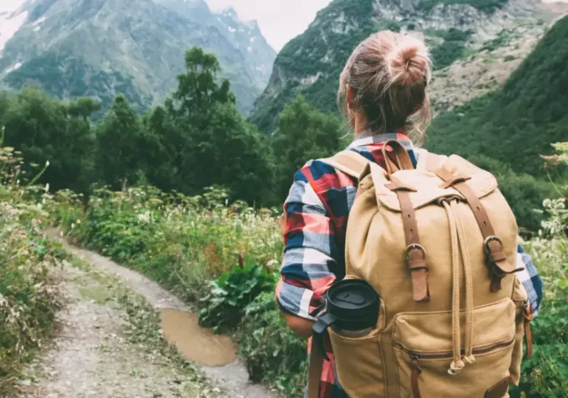 Hiker with a backpack walking a mountain trail