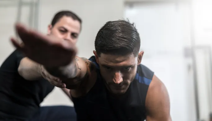 Coach guiding a client through a personalized strength training session