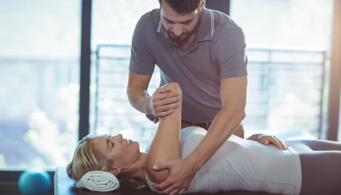 Doctor of Physical Therapy performing hands-on joint mobilization on a patient's spine